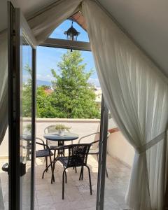 a patio with a table and chairs and a window at Thefamilyapartmentsinfethiye in Fethiye