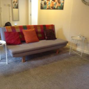 - un canapé avec des oreillers colorés dans l'établissement Marshfield Apartment, à Goole
