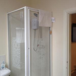 a bathroom with a shower with a glass door at Marshfield Apartment in Goole
