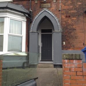 an entrance to a brick building with a black door at Marshfield Apartment in Goole