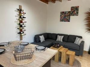 salon z kanapą i stołem z kieliszkami do wina w obiekcie Maison de ville a 5 min à pied de la tour Luma w mieście Arles