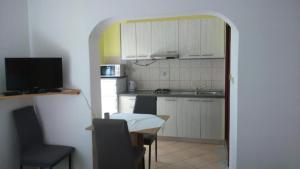 a kitchen with a table and a kitchen with a sink at Apartments Ninske Vodice in Nin