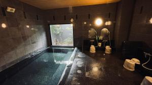 d'une salle de bains avec une piscine et une fenêtre. dans l'établissement Hotel Route-Inn Ichinoseki Inter, à Ichinoseki