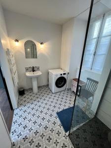 een badkamer met een wasmachine en een wastafel bij Treignac Place Studio in Treignac