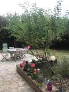 a garden with a table and a tree and some flowers at Belle chambre privée Cergy (dans le golf) proche RER A in Vauréal