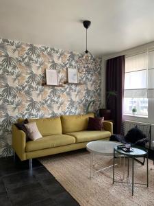 uma sala de estar com um sofá amarelo em frente a uma parede em Anna Flat em Gent
