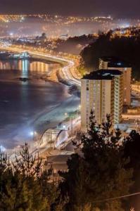 uma vista de uma cidade à noite com uma ponte em Departamento, Playa Bellavista, Tomé em Tomé