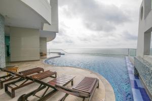 uma piscina com espreguiçadeiras e o oceano em Playa Cartagena Apartments em Cartagena de Indias