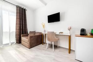 a living room with a chair and a television at Boutique Residence Arion in Rovinj