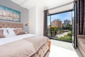 a bedroom with a bed and a large window at Boutique Residence Arion in Rovinj