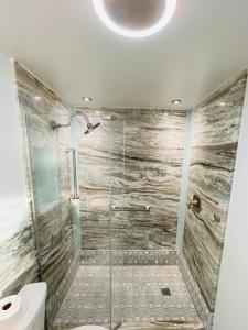 a bathroom with a glass shower with a toilet at Penthouse 6 Panoramic Ocean Views Top Floor in Fort Myers Beach