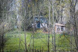 una casa en medio de un campo con árboles en slaměný domek, en Bystrá
