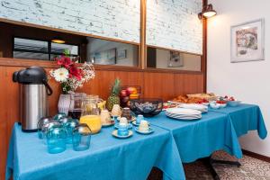 a table with a blue table cloth and dishes on it at Boutique Residence Arion in Rovinj