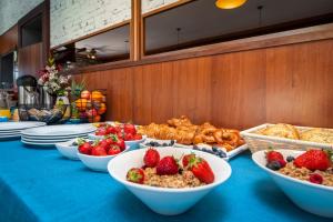 a blue table topped with bowls of fruit and bread at Boutique Residence Arion in Rovinj