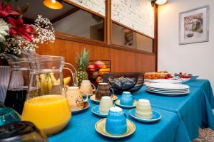 a blue table with plates and orange juice on it at Boutique Residence Arion in Rovinj