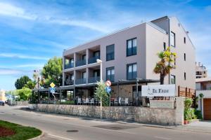 un edificio blanco con un restaurante en una calle en Boutique Residence Arion, en Rovinj