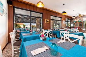 a restaurant with blue tables and white chairs at Boutique Residence Arion in Rovinj