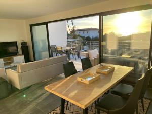 - un salon avec une table et des chaises en bois dans l'établissement Coucher de soleil, à Porticcio