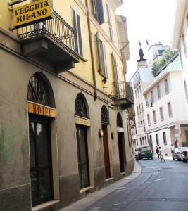 ein Gebäude mit einem Schild am Straßenrand in der Unterkunft Hotel Vecchia Milano in Mailand