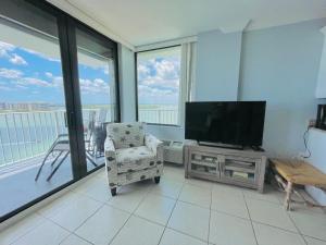 a living room with a flat screen tv and a chair at #1203 Lovers Key Beach Club in Fort Myers Beach