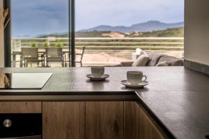 two cups of coffee on a counter with a balcony at Coucher de soleil in Porticcio