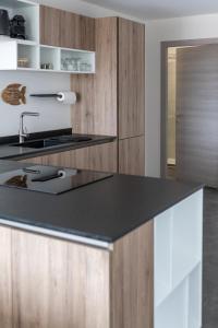 a kitchen with a black counter top and wooden cabinets at Coucher de soleil in Porticcio