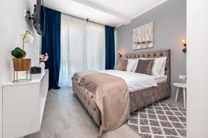 a bedroom with a large bed with blue curtains at Boutique Residence Arion in Rovinj