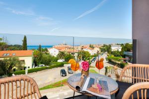 a table on a balcony with a view of a street at Boutique Residence Arion in Rovinj