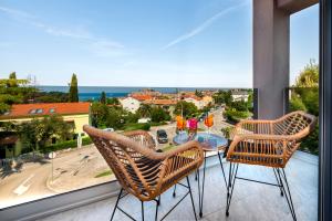 a balcony with a glass table and two chairs at Boutique Residence Arion in Rovinj