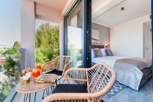 a bedroom with a balcony with a bed and a table and chairs at Boutique Residence Arion in Rovinj