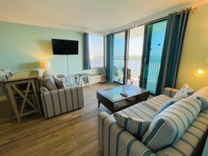 a living room with a couch and a table with a television at #1104 Lovers Key Beach Club Ocean Front in Fort Myers Beach