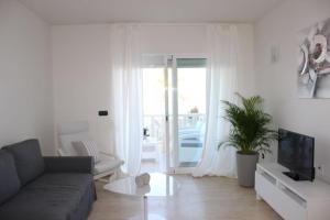 un soggiorno con divano e TV di Espectacular casa en la playa a Fuengirola