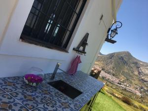 a table with a sink and a view of a mountain at La Sorpresa in Valle de Abdalagís