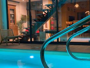a view of a swimming pool with a staircase in a house at Loft Spa Reims-fr 250m2 privatifs, piscine intérieure chauffée, spa et parking in Reims
