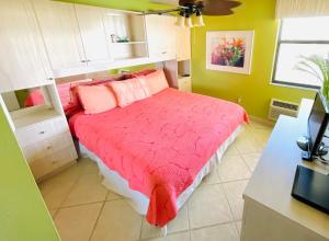 a bedroom with a bed with a red comforter at #903 Panoramic Ocean View at Lovers Key Beach Club in Fort Myers Beach +12 photos