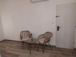 two chairs and a table in a room with a door at מדבריות השחר in Dimona
