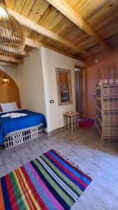 a bedroom with a bed and a rug in a room at Habiba Beach Lodge in Nuweiba
