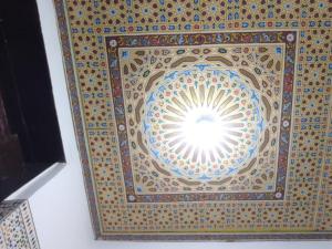 a ceiling of a building with a sun in the middle at Dar Ouassim in Fez