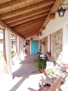 a porch with a blue door and wooden ceilings at Agriturismo Borghetto la radice in Roccaverano