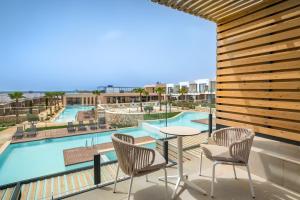 a balcony with a table and chairs and a pool at Barceló Nura in Sant Lluis