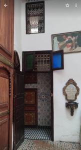 um quarto com uma porta e uma parede com azulejos em Dar Ouassim em Fez