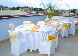a group of tables with yellow and white bows at Résidence L'écrin in Yaoundé