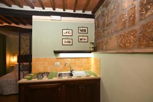 a kitchen with a sink and a brick wall at il Cantuccio in Pitigliano