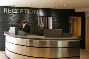 a woman standing at a reception counter in a hotel at Damon’s Hotel in Lincoln