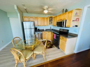 a small kitchen with a glass table and chairs at #901 Private Beach and Gulf Views in Fort Myers Beach