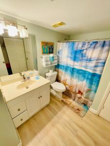 a bathroom with a sink toilet and a shower curtain at #901 Private Beach and Gulf Views in Fort Myers Beach