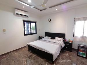 a bedroom with a large bed in a white room at RÉSIDENCE HÔTELIÈRE KAWEROU in Ouagadougou