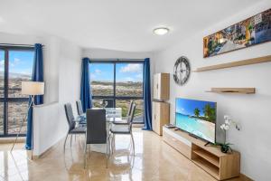 ein Wohnzimmer mit einem Esstisch und einem TV in der Unterkunft OCEAN BLUE, Next to the Ocean, Fast Wi-Fi in Los Abrigos