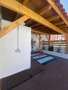 a patio with a wooden roof with a table and chairs at Casa dos Carvalhos in Coimbra