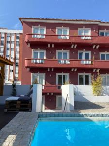 a building with a swimming pool in front of a building at Casa dos Carvalhos in Coimbra